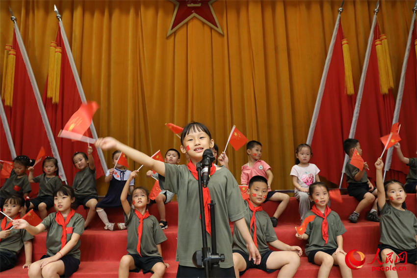 組織軍娃與國旗合影，培塑藍天娃愛國情懷。