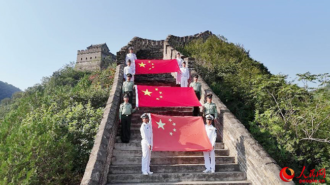 巍巍長城上，邊海防官兵展開來自高原和海島的國旗。賈思宇 攝