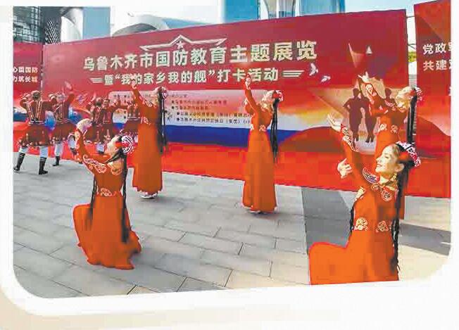 新疆烏魯木齊市國防教育主題展覽上，維吾爾族群眾表演民族歌舞。黨文彬攝