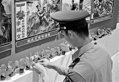 南部戰區陸軍某旅“英雄連”戰士在榮譽室內擺放木棉花。