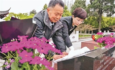 王太平父女擦拭杜治賢墓碑。顧建春攝