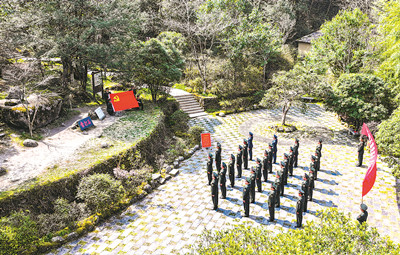 江西省井岡山市人武部官兵在“雷打石”前開展重溫入黨誓詞活動。肖  波攝