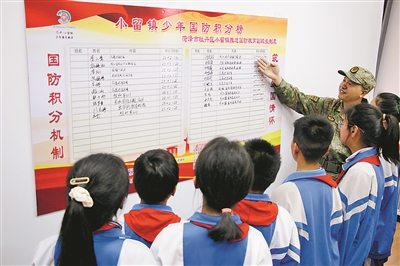 在小留鎮黨群服務中心，牡丹區人武部工作人員介紹“少年國防積分”榜上學生積分情況。劉繼璐攝