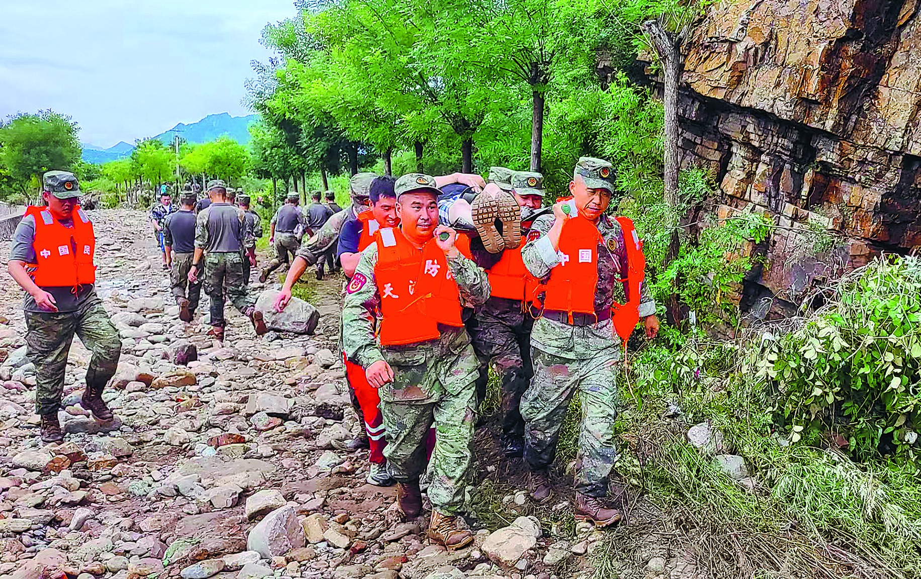 天津市薊州區民兵用擔架轉移行動不便的群眾。馬 帥攝