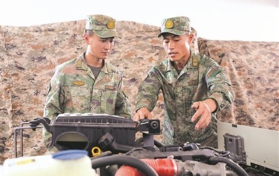 雷耀明（右）給戰友講解裝備操作要點。馬新周 攝