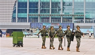 官兵正在徒步巡邏，身后跟隨一輛無人車。蔣林岫攝