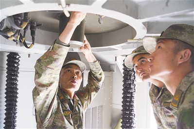 第76集團軍某旅一級軍士長關亞輝（左一）為戰友傳授修理經驗。 向禁垚攝