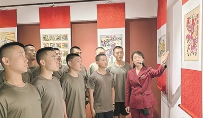 武強縣年畫博物館工作人員為預定新兵講述抗戰年畫背后的創作故事。夏洪濤 攝