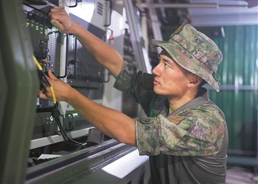信息支援部隊某旅軍士丁浩在演訓任務中調試裝備。李伯康攝