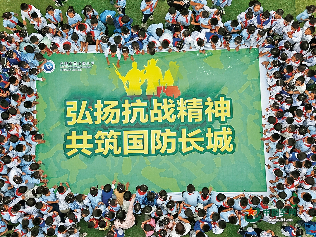 安徽省合肥市蜀山區人武部聯合當地學校開展國防教育進校園活動。圖為學生們在國防教育主題海報上簽名。葛宜年攝