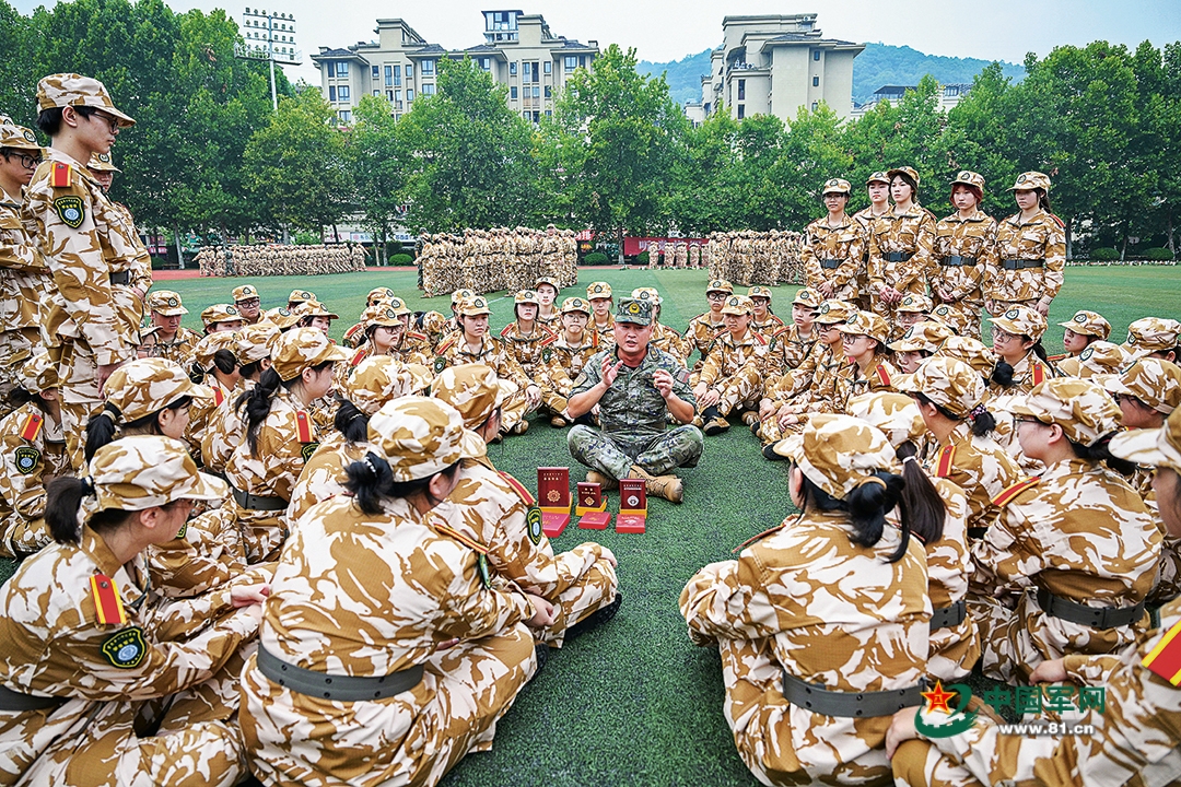武警重慶總隊機動支隊為駐地高校開展軍訓時，穿插組織國防教育活動。圖為一級上士安俊吉為學生們講述所獲獎章、紀念章背后的故事。本報特約通訊員  王  肸攝