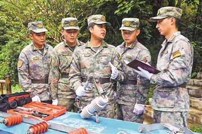 火箭軍某部電力連連長楊康（左三）正在為戰士講解專業操作。劉乙舉攝
