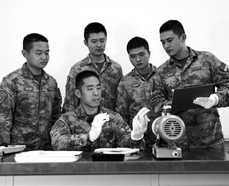 火箭軍某旅某營高級技師、一級軍士長毛偉（左二）正向班組戰友講解裝備組件原理。本報特約通訊員 李 昌攝